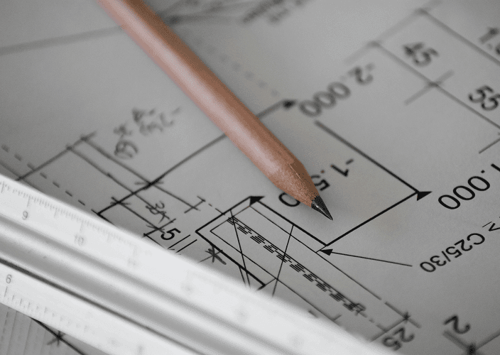 A pencil and ruler resting on a technical drawing.