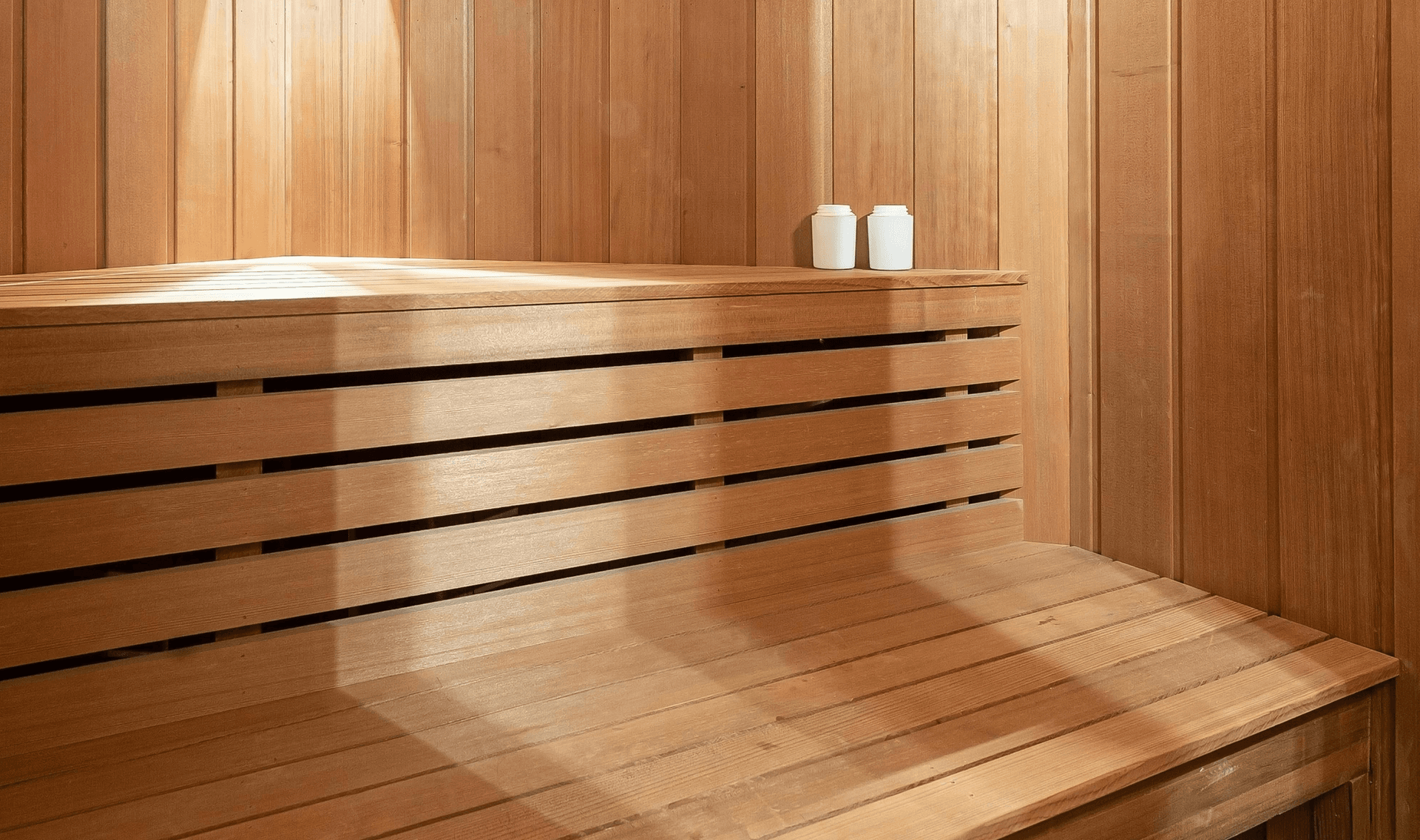 Photo of a wooden sauna bench with neatly folded white towels, emphasizing relaxation and wellness.