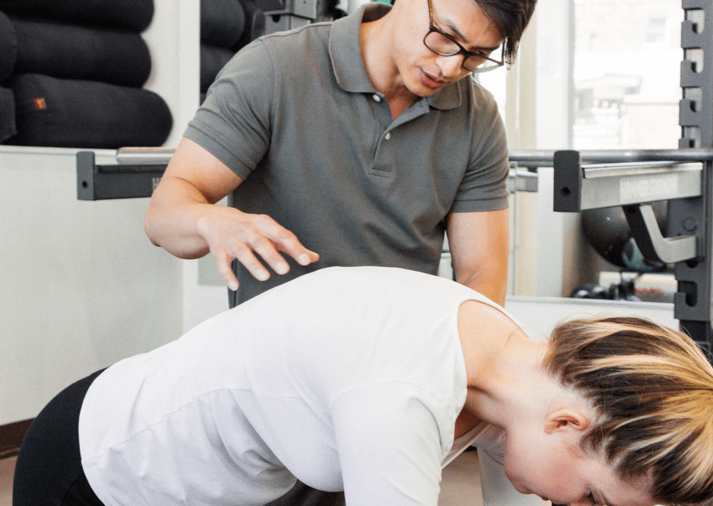 Photo of a therapist guiding a patient in a physical therapy session, focusing on posture correction exercises.