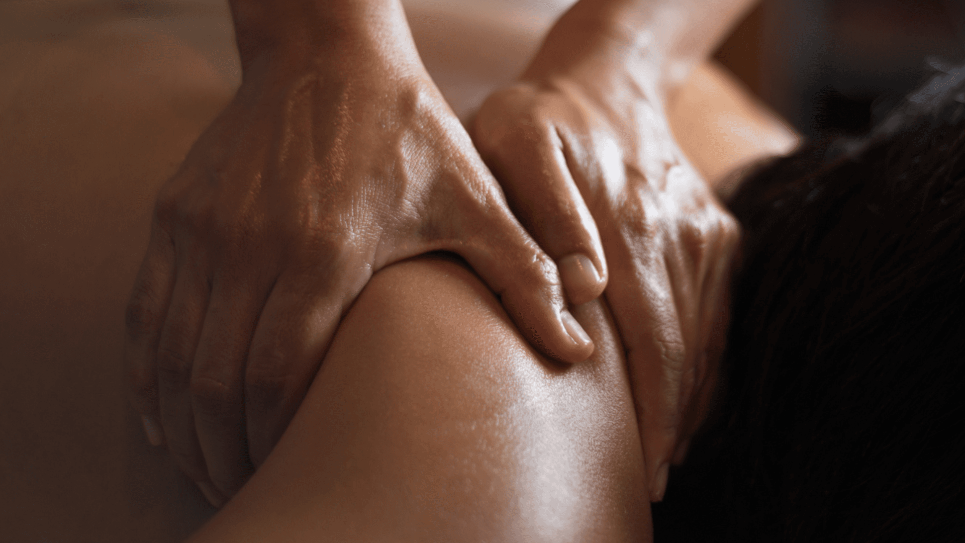Close-up photo of hands performing therapeutic massage, showing pressure application technique on skin surface.