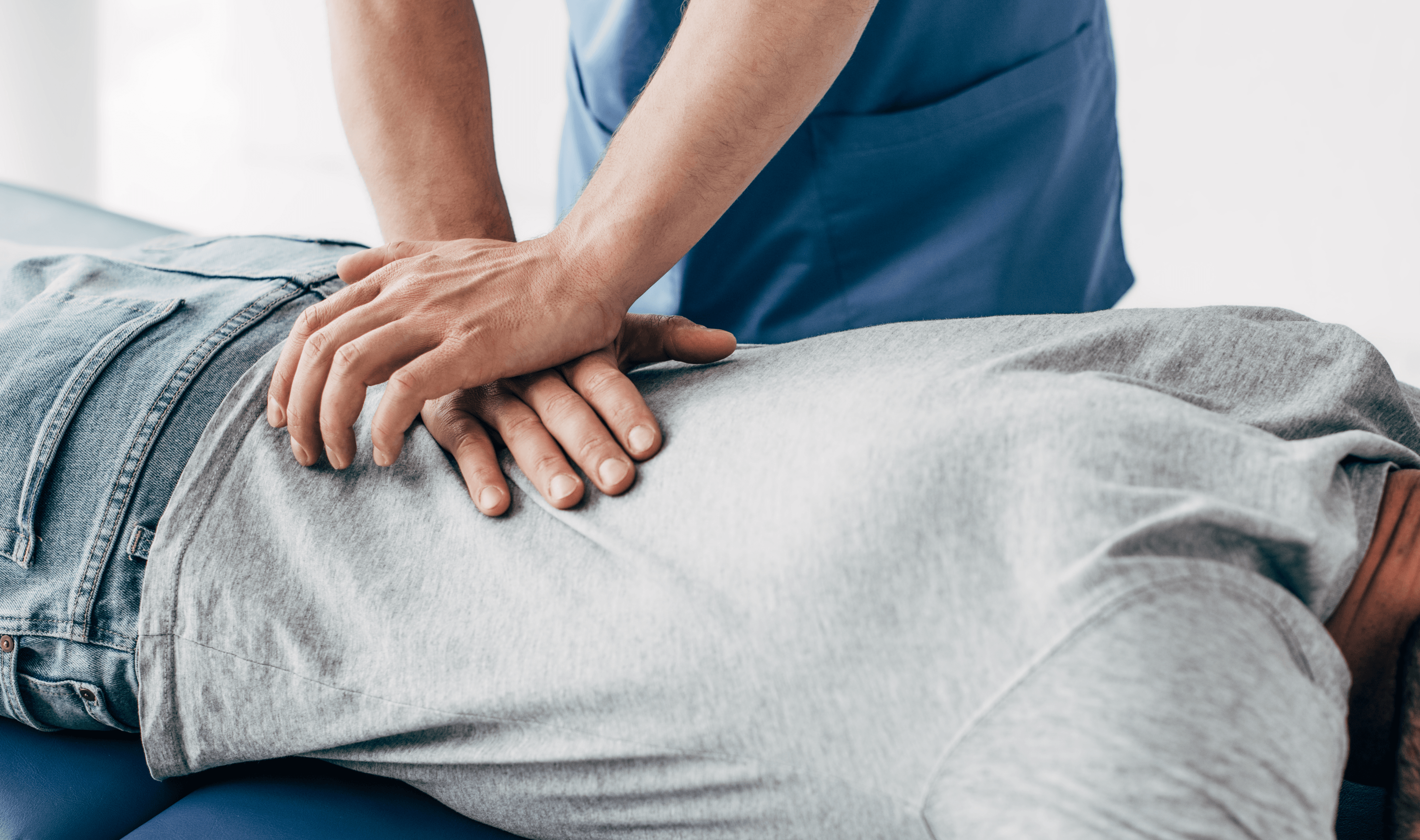 A photo showing hands performing a chiropractic or massage technique on a person's back.