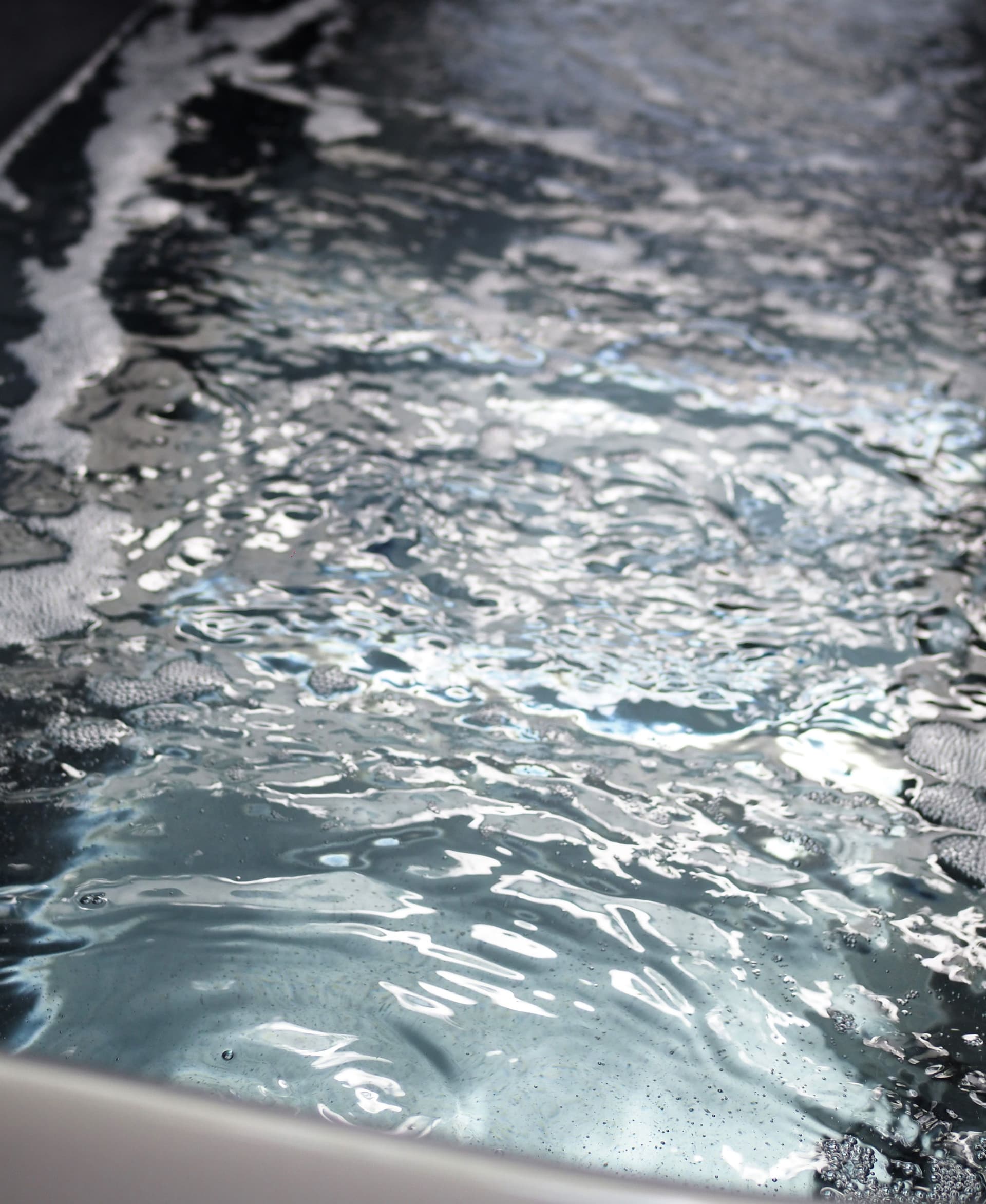 Close-up of water in a bath bubbling and rippling.